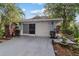 Exterior front view of a single-story home with a driveway, garage, and tropical landscaping at 9001 Sw 91St Cir, Ocala, FL 34481