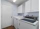 Laundry room with white washer, dryer and cabinets at 9001 Sw 91St Cir, Ocala, FL 34481