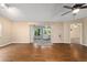 Bright living room with hardwood floors, ceiling fan, and sliding glass doors to the lanai at 9001 Sw 91St Cir, Ocala, FL 34481
