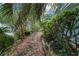 Picturesque side yard featuring a wooden walkway and mature trees at 9001 Sw 91St Cir, Ocala, FL 34481