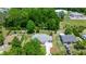A high-angle view highlights a single-Gathering home with a spacious yard, located in a neighborhood surrounded by lush trees at 9021 Sw 108Th Pl, Ocala, FL 34481