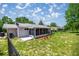 Fenced backyard with screened in patio, mature trees and green grass, perfect for enjoying the outdoors at 9021 Sw 108Th Pl, Ocala, FL 34481
