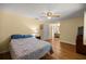 Bedroom features a ceiling fan, ensuite bathroom, and wood-look flooring at 9021 Sw 108Th Pl, Ocala, FL 34481