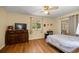 Cozy bedroom featuring warm wall colors, a ceiling fan, and wood-look floors at 9021 Sw 108Th Pl, Ocala, FL 34481