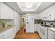 Bright kitchen features white cabinets, modern appliances, wood-look floors, and ample counter space at 9021 Sw 108Th Pl, Ocala, FL 34481