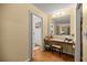 Bedroom vanity with a stool and a mirror, next to a bathroom entrance at 9021 Sw 108Th Pl, Ocala, FL 34481