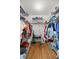 Spacious walk-in closet with an organized storage system, shelving, rods, and hardwood floors at 9021 Sw 108Th Pl, Ocala, FL 34481
