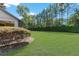 Expansive backyard with lush green grass, mature trees, and a well-maintained privacy hedge at 9170 Sw 65Th Loop, Ocala, FL 34481