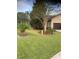 Lush front yard with green grass, palm trees, and a beautifully landscaped garden area, offering great curb appeal at 9170 Sw 65Th Loop, Ocala, FL 34481