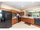 Modern kitchen with black appliances, wood cabinets, and a convenient breakfast bar at 9170 Sw 65Th Loop, Ocala, FL 34481