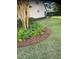 Well-maintained landscaping bed with verdant foliage, complementing the green lawn surrounding the property at 9170 Sw 65Th Loop, Ocala, FL 34481