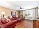 Comfortable living room featuring a red leather sofa, hardwood flooring, and large window at 9170 Sw 65Th Loop, Ocala, FL 34481