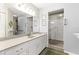 Bright bathroom featuring a large mirror, vanity with storage, and tiled walk-in shower with glass doors at 9266 Sw 91St Cir, Ocala, FL 34481