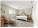 Comfortable bedroom with wood floors, light walls, and large window at 9266 Sw 91St Cir, Ocala, FL 34481