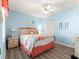 Bright bedroom with blue walls, a ceiling fan, wood floors, and closet storage at 9266 Sw 91St Cir, Ocala, FL 34481