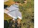 Aerial view of home with modern metal roof, light siding, and surrounding mature trees at 9330 Se 106Th Pl, Belleview, FL 34420