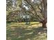 Spacious backyard features mature trees and two Adirondack chairs at 9330 Se 106Th Pl, Belleview, FL 34420