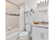 Bathroom features a shower/tub combo, granite vanity and neutral tile at 9330 Se 106Th Pl, Belleview, FL 34420