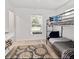 Well-lit bedroom with a bunk bed, neutral color scheme and simple decorations at 9330 Se 106Th Pl, Belleview, FL 34420