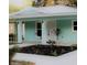 Charming home with teal siding, decorative metal roof accents, and manicured landscaping at 9330 Se 106Th Pl, Belleview, FL 34420