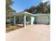 Teal home featuring covered porch, attached garage, and lush landscaping at 9330 Se 106Th Pl, Belleview, FL 34420