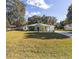 Single story home with light teal paint, covered porch, metal roof and lush green front lawn at 9330 Se 106Th Pl, Belleview, FL 34420
