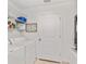 Bright laundry room features a washing machine, dryer, shelving, and a charming decorative sign at 9330 Se 106Th Pl, Belleview, FL 34420