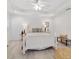 Bright main bedroom boasts tray ceiling, white wood bed frame, and neutral decor at 9330 Se 106Th Pl, Belleview, FL 34420