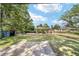 Large backyard with lush green grass, mature trees, and a storage shed at 11 Se Fir Trail Trak, Ocala, FL 34472