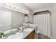 Bathroom features a double vanity and shower with a new curtain rod and soft accent decor at 11 Se Fir Trail Trak, Ocala, FL 34472