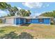 Charming single-story home features a blue exterior, attached garage, and well-kept lawn at 11 Se Fir Trail Trak, Ocala, FL 34472