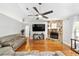Open-concept living room with hardwood floors, fireplace, ceiling fan, and comfortable sectional sofa at 11 Se Fir Trail Trak, Ocala, FL 34472