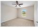 Carpeted bedroom with a view through a window, and a ceiling fan at 1143 Sw Tamiami Pl, Dunnellon, FL 34431