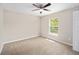 Carpeted bedroom featuring a ceiling fan, a window, and closet access at 1143 Sw Tamiami Pl, Dunnellon, FL 34431