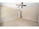 A carpeted bedroom includes a ceiling fan and access to a bathroom at 1143 Sw Tamiami Pl, Dunnellon, FL 34431