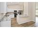 Modern kitchen featuring white cabinetry, stainless steel appliances, and granite countertops with a breakfast bar at 1143 Sw Tamiami Pl, Dunnellon, FL 34431