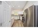 Well-lit kitchen featuring stainless steel refrigerator, white cabinets, granite counters, and sleek appliances at 1143 Sw Tamiami Pl, Dunnellon, FL 34431