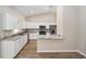 Modern kitchen featuring white cabinetry, stainless steel appliances, and granite countertops with a breakfast bar at 1143 Sw Tamiami Pl, Dunnellon, FL 34431