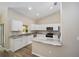 Bright, open kitchen with white cabinets, stainless steel appliances, granite countertops, and ample natural light at 1143 Sw Tamiami Pl, Dunnellon, FL 34431