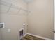 Well-lit laundry room with wooden floors and wire shelving for ample storage at 1143 Sw Tamiami Pl, Dunnellon, FL 34431