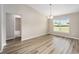 Open-concept living area with durable floors, neutral paint, and bathroom entrance at 1143 Sw Tamiami Pl, Dunnellon, FL 34431