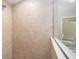 A close-up of the shower features neutral tile, glass surround, and a shower head at 1143 Sw Tamiami Pl, Dunnellon, FL 34431