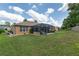 View of backyard with a screened patio and well-maintained lawn with a blue sky in the background at 12804 Se 90Th Court Rd, Summerfield, FL 34491