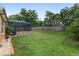 Expansive backyard with lush green grass and a screened-in pool area providing ample space for outdoor activities at 12804 Se 90Th Court Rd, Summerfield, FL 34491