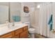 Bright bathroom featuring a wood vanity, tub with shower, and charming sun decor at 12804 Se 90Th Court Rd, Summerfield, FL 34491