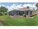 Wide-angle view of a well-maintained backyard featuring a screened-in pool and lush green lawn at 12804 Se 90Th Court Rd, Summerfield, FL 34491