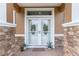 Close-up of the home's front door with stone accents and decorative glass at 12804 Se 90Th Court Rd, Summerfield, FL 34491