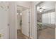 Hallway view of bedroom and adjoining bathroom featuring a glass-enclosed shower at 12804 Se 90Th Court Rd, Summerfield, FL 34491