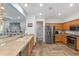 Open kitchen with stainless steel appliances, light cabinets, and an eat-in bar connecting to the living area at 12804 Se 90Th Court Rd, Summerfield, FL 34491