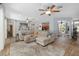 Spacious living room with a large sectional sofa, ceiling fans, and open access to kitchen and dining area at 12804 Se 90Th Court Rd, Summerfield, FL 34491